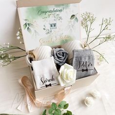 two towels in a gift box with flowers and congratulations message on the front, sitting next to each other