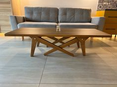 a coffee table sitting on top of a tile floor next to a couch and chair