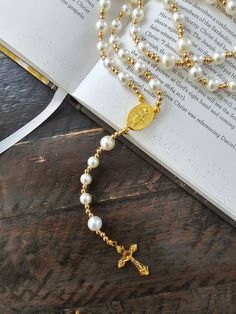 This beautiful handmade Catholic pearl rosary necklace is a perfect religious gift for any occasion. It features a 22-inch length with 8mm and 10mm beads in white and gold colors, and a 1.32" x 0.81" cross with a holy Mary medal. The rosary is made of high-quality pearl material and has a silver and gold color combination. This rosary is suitable for women, men, girls, and boys of any age, and it is a perfect choice for anyone who practices Christianity. It is a collectible item that can be cher Elegant Pearl Rosary For First Communion, Pearl White Rosary With 8mm Beads As Gift, White Pearl Rosary As A Gift, Spiritual Pearl Rosary As Gift, White Pearl Rosary As Gift, Pearl Rosary With 8mm Beads As Gift, Spiritual Pearl White Rosary Gift, Pearl White Spiritual Rosary As Gift, Spiritual Pearl White Rosary As Gift