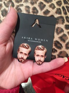 a person holding up a card with an image of two men's faces on it