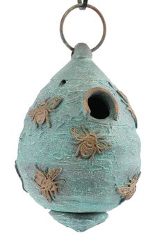 a green birdhouse with bees on it's side and a key chain hanging from the front