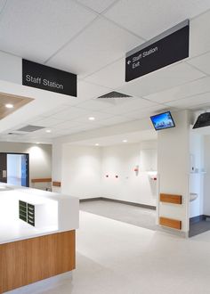 an empty waiting area with signs on the wall and ceiling above it that read staff station exit