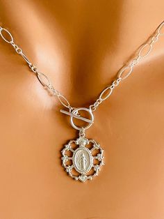 "This is a 14k gold filled oval long link chain necklace with detailed medium size Miraculous medallion.  This unique necklace features a 23x21mm elegant miraculous medal of Mary made of 16k gold plating over 925 sterling silver that hangs on a toggle and textured 7x5mm link chain. Model is wearing a 15\" and a 16\"  length. Choose your desired length in the drop-down list. This necklace is stunning! Comes in a cute gift box! Also available in shiny 925 sterling silver or 925 oxidized sterling silver." Miraculous Medal Necklace, Protection Jewelry, Necklaces Gold, Cute Gift Boxes, Charm Necklaces, Miraculous Medal, Unique Necklace, Oxidized Sterling Silver, Chain Link Necklace