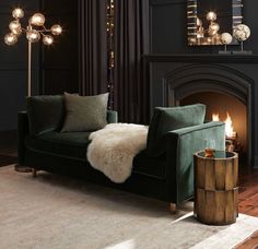 a living room filled with furniture and a fire place in front of a black wall