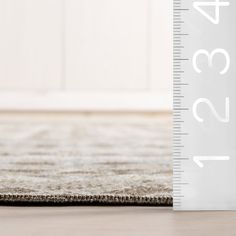 a ruler is on the floor next to a rug