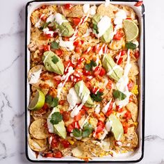 an enchilada dish with tortillas, avocado and sour cream