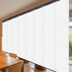 a dining room table and chairs with sliding glass doors on the wall in front of it