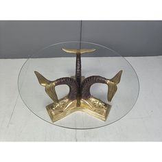 a glass table topped with a gold sculpture