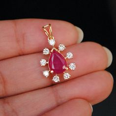 "Bright red ruby is surrounded by tiny diamonds in a scattered halo. This pendant is a perfect gift idea. Item Details * Main Gemstone : Natural Untreated Red Ruby * Halo : Natural White Diamonds * Ruby : 1.40 - 1.50 cts (Approx) * Diamond Weight : 0.40 cts * Color - Clarity Grade : H-I, Vs-Si (Halo) * Gold - 1.80 gms. 14k Solid White Gold * Dimensions - 12 x 8 mm (excluding vale) ( Pending) PLEASE NOTE : This listing is ONLY for the PENDANT. Chain is only for props. Your purchase will arrive in Red Cluster Diamond Jewelry, Cluster Ruby Jewelry With Diamond Accents, Red Ruby Jewelry With Single Cut Diamonds, Ruby Cluster Jewelry With Diamond Accents, Red Cluster Jewelry With Diamond Accents, Red Diamond Jewelry With Rose Cut Diamonds, Red Rose Cut Diamond Jewelry, Ruby Cluster Jewelry With Halo Setting, Oval Diamond Engagement