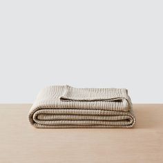 two folded linens sitting on top of a wooden table