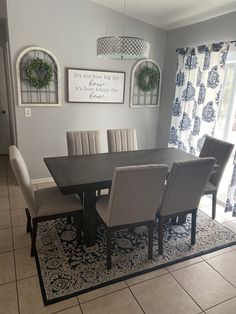 a dining room table with chairs and rugs on the floor in front of it