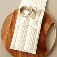 a wooden plate topped with a napkin and silverware