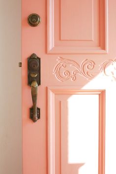 a pink door with an ornate handle on it