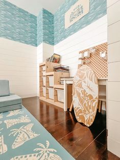 a surfboard sitting on top of a wooden floor next to a blue and white wall