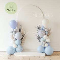 some balloons are hanging on the wall in front of a white and light blue backdrop