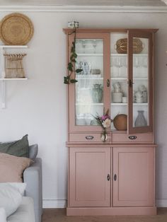 a pink china cabinet in a living room