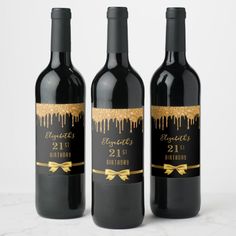 three bottles of wine with gold foil on them