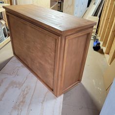 a large wooden box sitting on top of a counter in a room with unfinished walls