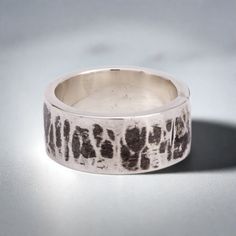 This "Kimiko" silver ring is handmade in 925 Sterling Silver in my workshop. The ring is hand crafted using a 92.5% pure silver flat piece, bent to shape, soldered, hammered and oxidized to give that special finish. The finish of this ring is inspired by the "Mokume-gane" distinctive pattern found on japanese swords. Materials: 92.5% pure solid silver Band width: 3/8 inch (10 mm) Ring size: 6 (This is a unique creation. Because of the special finish, it cannot be reproduced or resized. Only one size available. I cannot adjust the ring size) Hand Cast Wide Band Silver Sterling Ring, Hand Cast Sterling Silver Wide Band Ring, Hand Forged Silver Ring With Thick Band, Hand Forged Sterling Silver Rings With Thick Band, Hand Forged Wide Band Sterling Silver Ring, Hand Forged Sterling Silver Wide Band Ring For Anniversary, Unique Hand Cast Sterling Silver Wide Band Ring, Hand Forged Sterling Silver Engraved Ring, Unique Hand Forged Sterling Silver Wide Band Ring