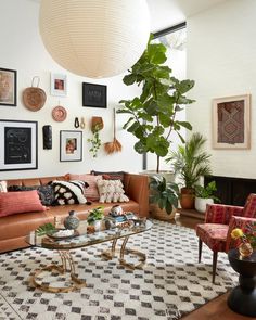 a living room filled with lots of furniture next to a large plant in a vase