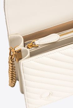 Classic Love Bag Click in quilted nappa leather with chevron design. The concealed press-stud fastening is embellished by the iconic metal Love Birds Diamond Cut buckle with cut-out effect. The accessory boasts a suede-look microfibre-lined interior, complete with a zipped centre divider pocket and slip pocket. The shoulder strap combines the round-link metal chain with a practical, adjustable leather shoulder pad. Activate your PINKO bag: verify the authenticity of your product and access a per Classic Love, Chevron Design, Press Studs, Nappa Leather, Love Birds, Diamond Cut, Metal Chain, Shoulder Pads, Antique Gold