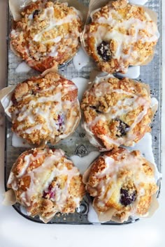 freshly baked muffins with icing and cranberries on a baking tray