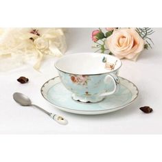 a tea cup and saucer sitting on top of a plate with flowers in the background