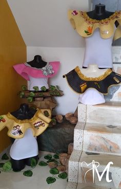 three mannequins with hats on their heads are displayed in front of a wall