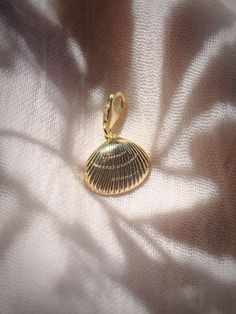 Add to your story with this gold sea shell charm. Choose from a regular jump loop or lobster clasp to make it your own.Planning on purchasing a chain for this and need help attaching it? Let us know and leave a note during checkout! This item will arrive separate/detached if no note is left.✦ DETAILS ✦✧ Gold Filled Sea Shell Pendant - 15mm x 17mm.✧ 14kt Gold Filled Loop or Clasp✧ Chains sold separately.✧ All Ke Aloha Jewelry pieces come packaged thoughtfully, beautifully, and ready for gift givi Gold Round Pendant Charm With Lobster Clasp, Yellow Gold-plated Charms With Lobster Clasp, Gold Jewelry With Starfish Charm, Gold Metal Jewelry With Starfish Charm, Gold Round Pendant Charm With Pearl, Elegant Gold Shell With Lobster Clasp, Gold Shell-shaped Jewelry With Starfish Charm, Gold Shell With Lobster Clasp As Gift, Brass Charms With Lobster Clasp For Gift