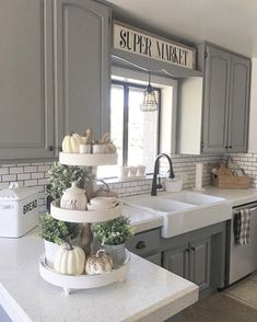 a kitchen with gray cabinets and white counter tops