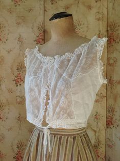 "breath taking fresh antique camisole, wedding top. sleeveless lace summer top in excellent condition. bust 92 cm 36\" waist 66 cm 26\" length 38 cm 15\" the shoulders have ruffled lace and made on them you can see see little roses made of soft silk ribbons" White Sleeveless Cotton Lace Top, White Cotton Lace Sleeveless Top, Fitted Cami Blouse For Daywear, White Lace Bodice With Lace Trim, Lace Camisole With Lace Trim For Daywear, Lace Trim Camisole For Daywear, Sleeveless Lace Top With Delicate Detailing, Fitted Camisole Blouse For Daywear, Sleeveless Fitted Lace Trim Bodice