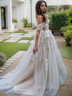 a woman in a wedding dress standing outside