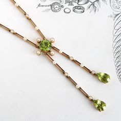 "An elegant antique necklace, circa 1900, featuring genuine peridot of vivid saturation and bright sparkle; the creamy white pearls that dot the links have a soft glow, perfectly accenting the rich green color of the gems. This particular configuration is known as a \"negligee necklace\" or \"negligee drop\", a long necklace terminating in drops or tassels of irregular length; it's a design that well-suited the necklines and delicate dressmaker details of the Edwardian era, and makes a chic stat Custom Gift Boxes, Antique Necklace, Edwardian Era, Wedding Jewellery Necklace, Wedding Necklace, Pearl White, Dressmaking, Long Necklace, Green Colors