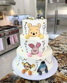 a winnie the pooh birthday cake on top of a kitchen counter with an oven in the background