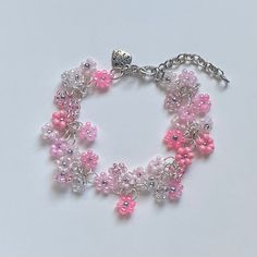 "A sweet handmade bracelet ✿ Made with glass seed beads and silver accents ✿ An assortment of pinks, bubblegum, blush, rose, milky white, and silver ✿ The bracelet has an additional 1-1.5\" of extension chain" Pink Flower-shaped Beaded Charm Bracelet, Adjustable Pink Beaded Bracelet With Silver Beads, Pink Flower Charm Bracelet For Jewelry Making, Pink Nickel-free Charm Bracelet, Adjustable Pink Jewelry With Silver Beads, Pink Hypoallergenic Beaded Bracelets, Pink Beaded Flower Charm Bracelet, Pink Beaded Charm Bracelet, Pink Bracelets With Flower Charm And Round Beads