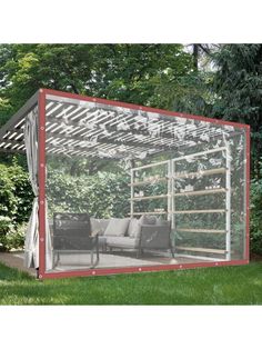 a couch sitting inside of a glass enclosure on top of a lush green field with trees in the background