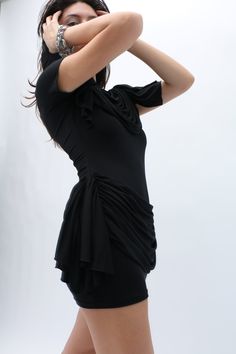 NOTE: This is a PRE-ORDER purchase. This piece will ship Early December 2024. This black jersey mini dress boasts a classic T-shirt silhouette, elevated by draping fabric that gracefully cascades along the chest, waist, and bum, creating a dramatic statuesque effect. Fit and material suits many body types. Draping Fabric, Draped Dress, Body Types, Dresses Xs, Classic T Shirts, Mini Dress, Fabric, Black