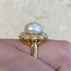 This beautiful ring features a natural saltwater button pearl weighing 21.48 chows. The pearl is adorned with a halo of old mine cut diamonds, which form a floral design and have a total approximate weight of 1.44 carats. This ring is handcrafted in 18k yellow gold.
The measurements of the natural pearl are 10.4mm. The measurements of this ring are 16.67mm x 16.82mm including the diamond halo.
This ring can be resized to any finger size at no extra cost.
If you have any questions about the Bayvi Estate Diamond Jewelry, Baguette Cut Diamond, Natural Pearl, The Pearl, Vintage Engagement, Beautiful Ring, Diamond Halo, Natural Pearls, Vintage Engagement Rings