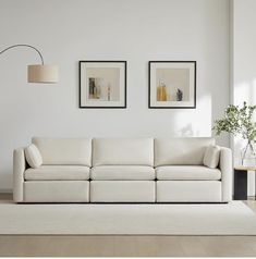 a living room with two pictures on the wall and a white couch in front of it