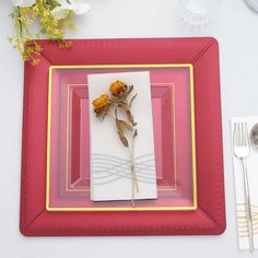 a place setting with napkins, silverware and flowers on the table top in front of it