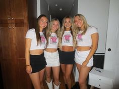 four girls in white shirts and black shorts posing for the camera