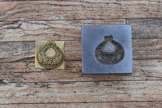 two different types of metal stamping on wooden background, one with an ornate design and the other without