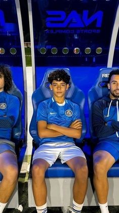 three soccer players are sitting on the bench