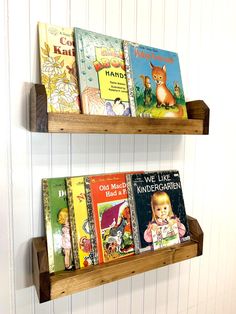 two wooden bookshelves holding children's books on the wall in a child's room