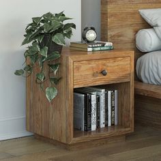 a nightstand with books and a clock on it next to a bed in a room