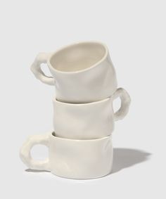 three white cups stacked on top of each other