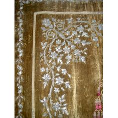 an embroidered cloth with white flowers and leaves on brown ground, in the shape of a square