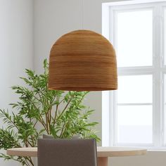 a chair sitting in front of a window next to a table with a potted plant on it