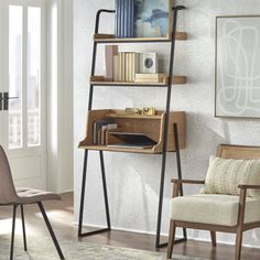 a room with a chair, bookshelf and pictures on the wall in it