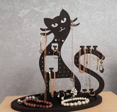 a black cat with many necklaces on it's neck and earring holder